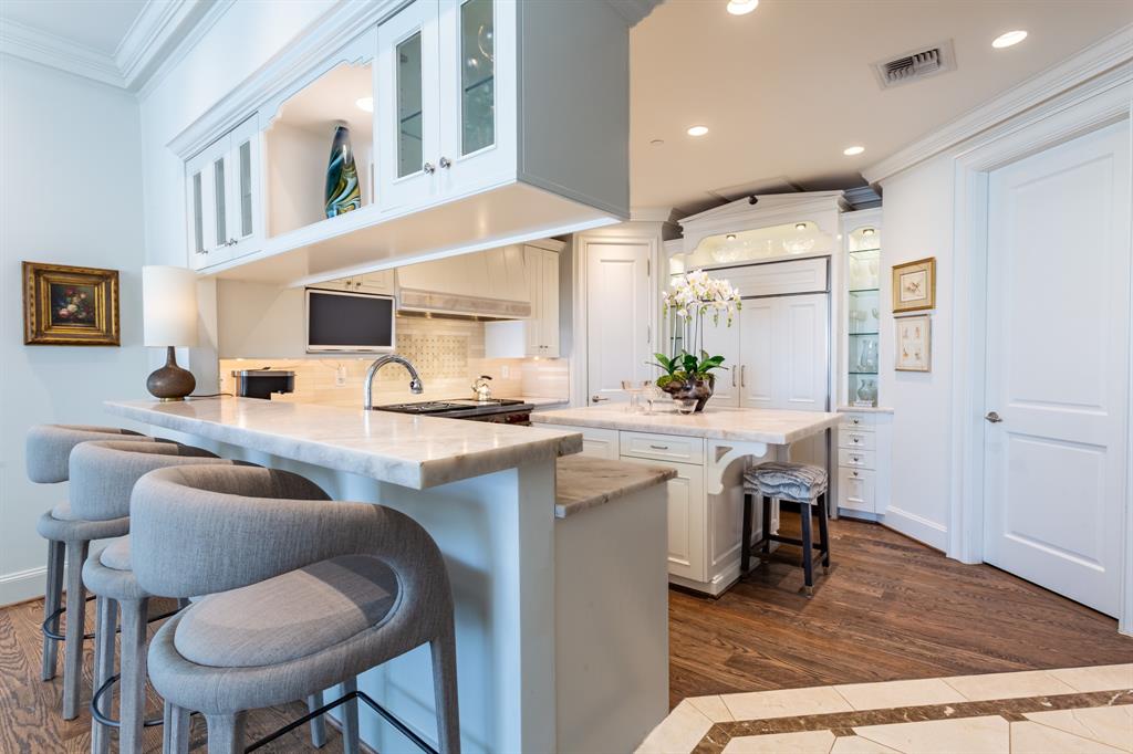 2525 North Pearl Street, Unit 1005 Dallas, TX 75201 - Photo 13 of 40 a kitchen with stainless steel appliances kitchen island granite countertop a sink and cabinets