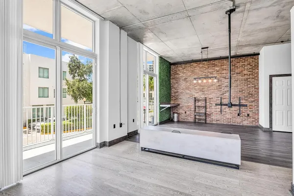 a spacious bedroom with a large window and a balcony