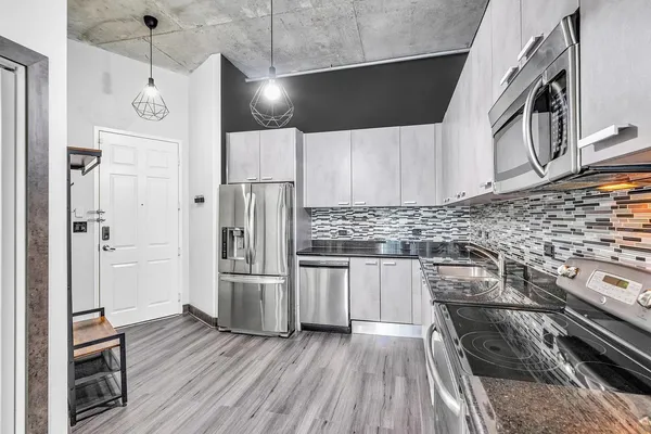 a kitchen with stainless steel appliances and wooden floor