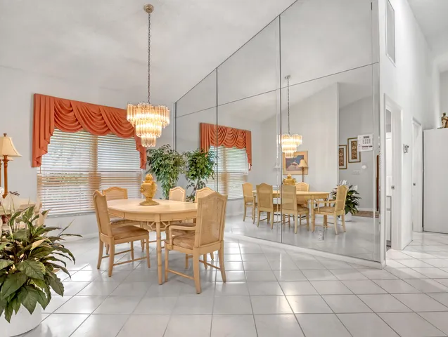 a very nice looking dining room with kitchen island furniture a chandelier and a chandelier