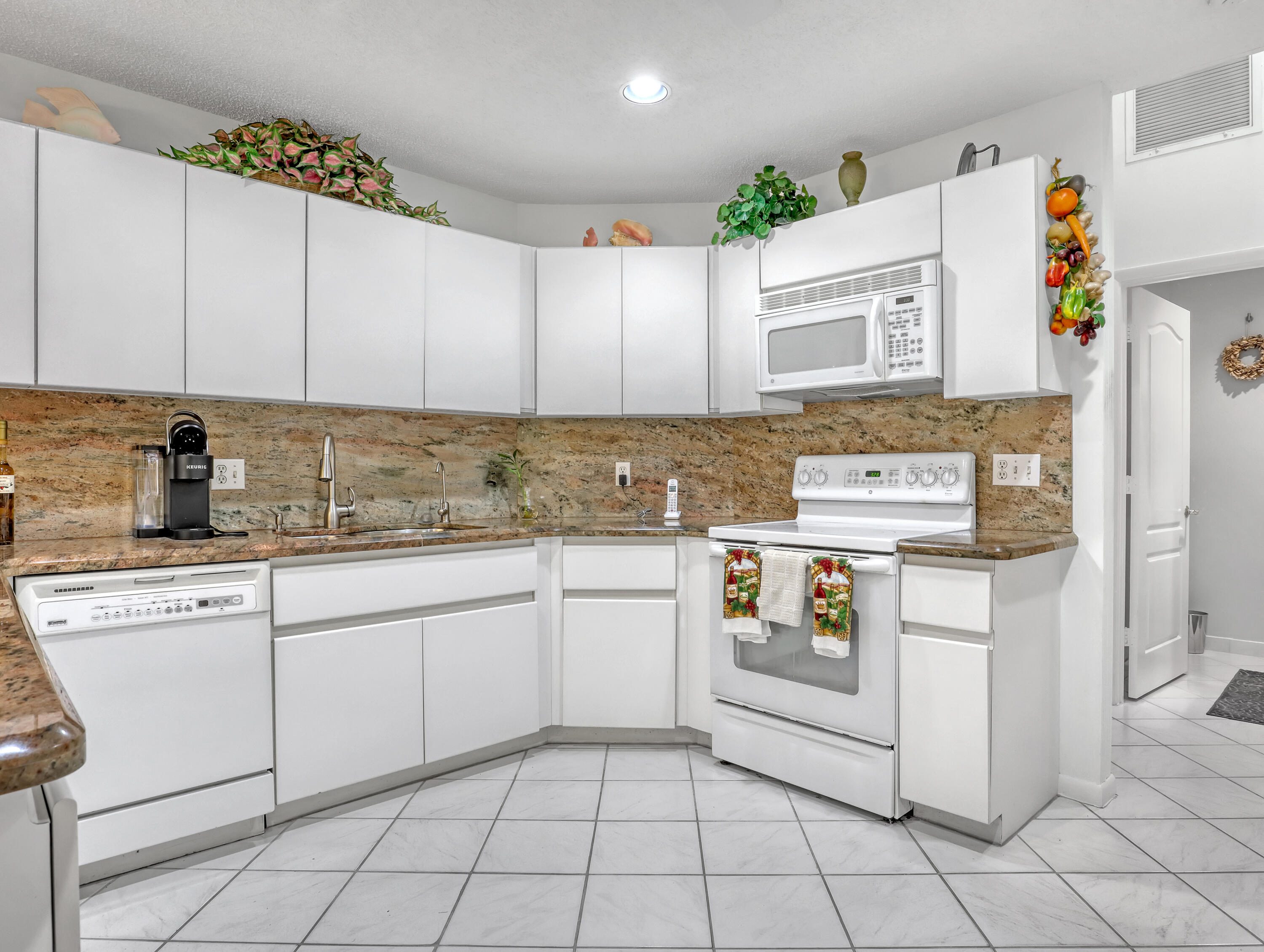 712 Golf Court Delray Beach, FL 33445 - Photo 19 of 46 a kitchen with a stove top oven sink and cabinets