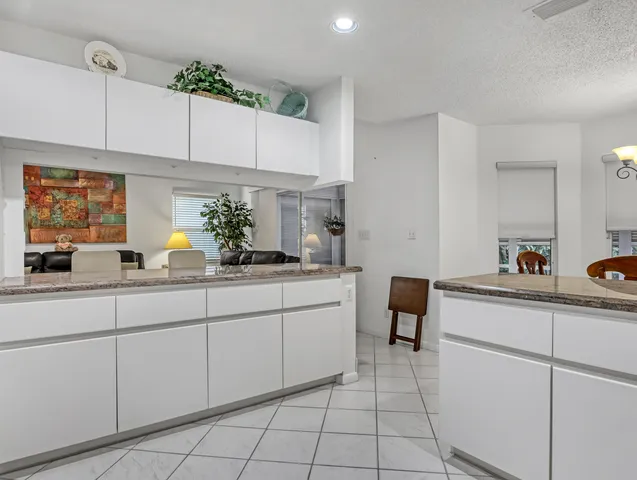 a kitchen with granite countertop white cabinets a sink and dishwasher
