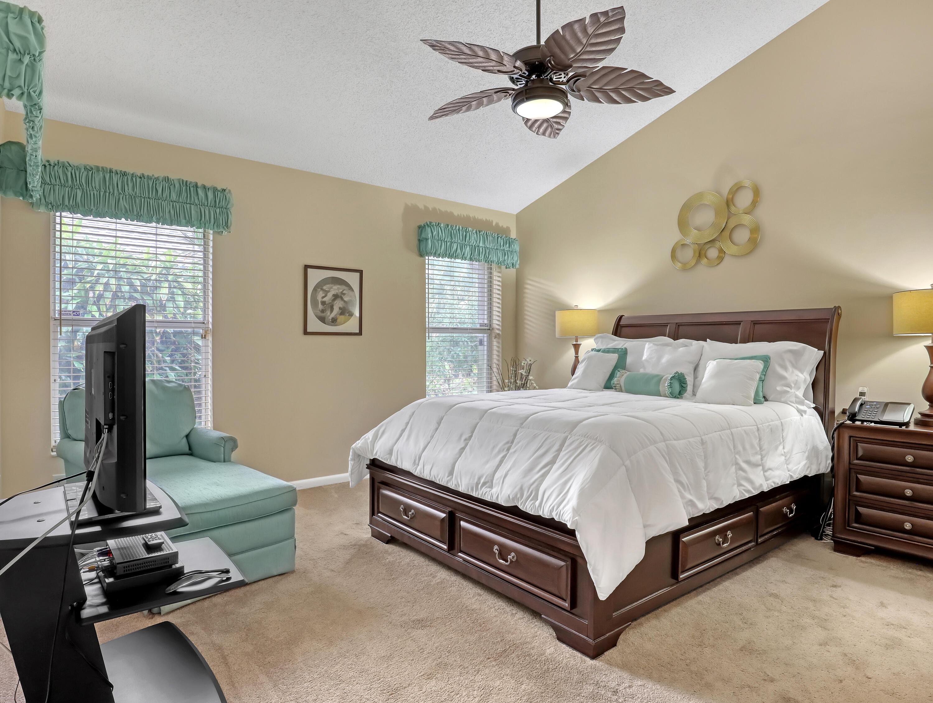 712 Golf Court Delray Beach, FL 33445 - Photo 23 of 46 a spacious bedroom with a bed and a chandelier