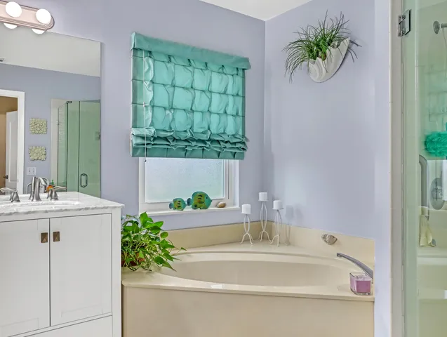 a bathroom with a tub shower and mirror