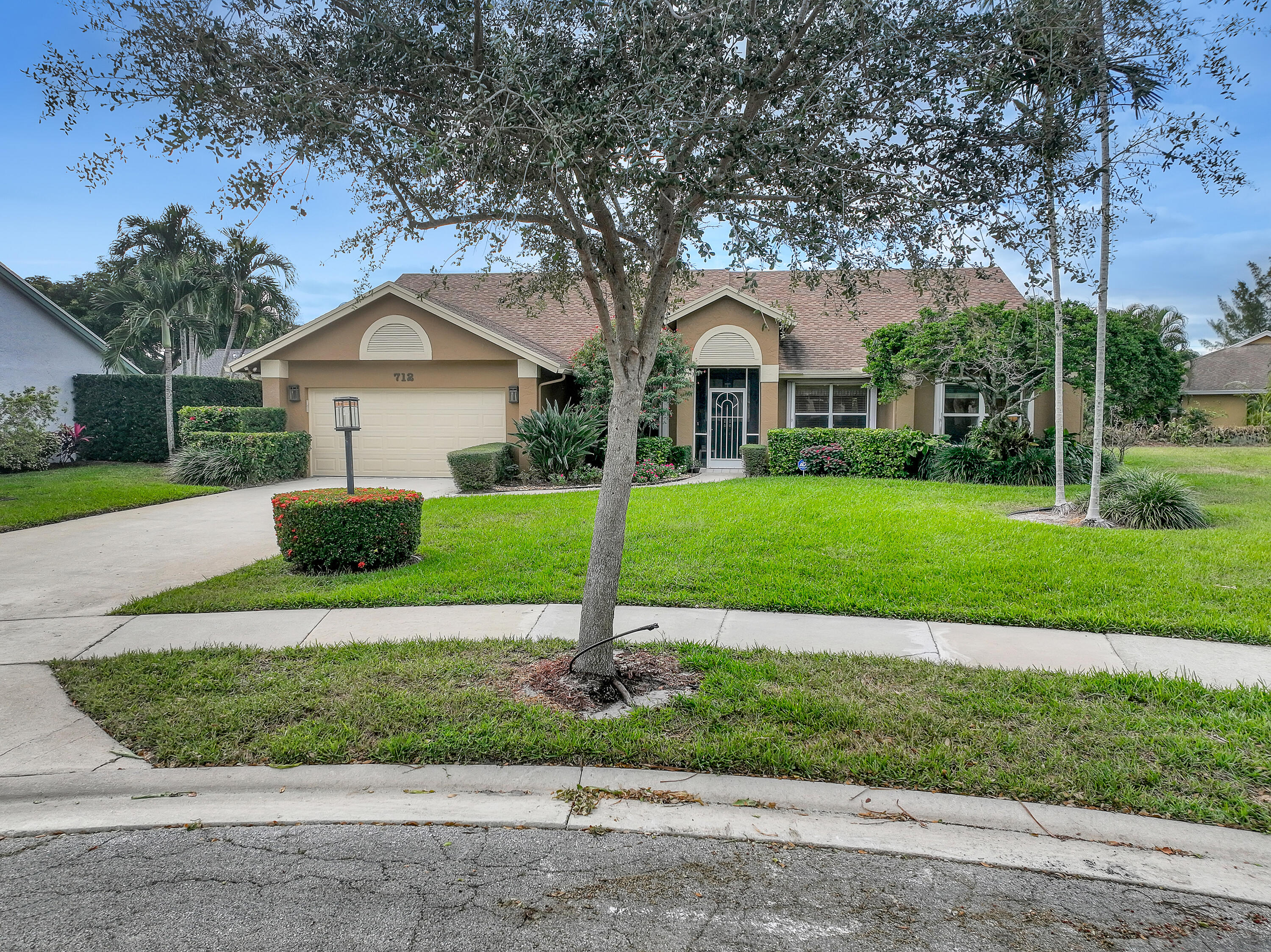 712 Golf Court Delray Beach, FL 33445 - Photo 40 of 46 a front view of a house with a yard and garage