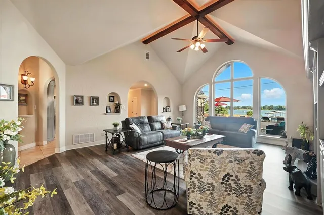 a living room with furniture a chandelier and wooden floor