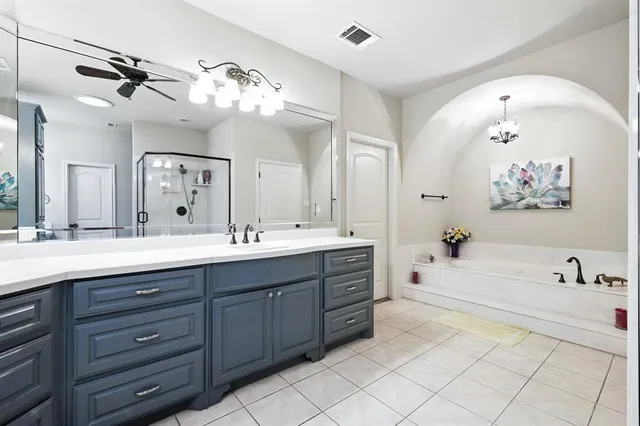 a spacious bathroom with a granite countertop sink mirror and bathtub