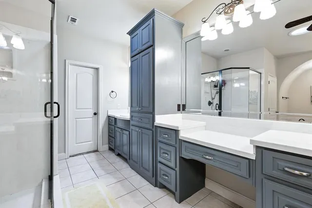 a spacious bathroom with a double vanity sink mirror and shower