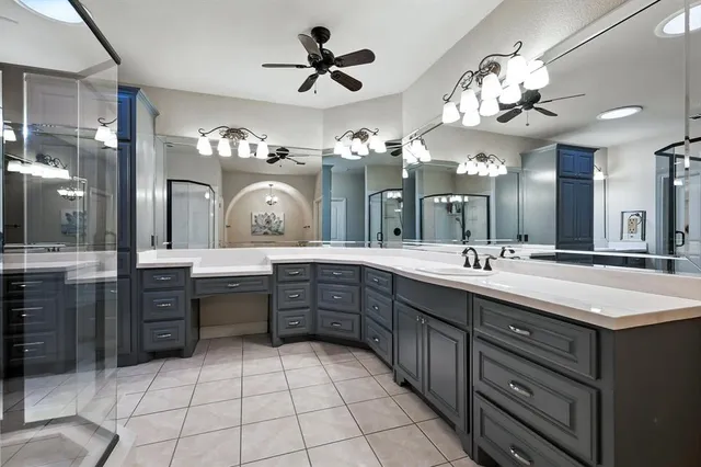 a spacious bathroom with a granite countertop sink a a mirror and a shower