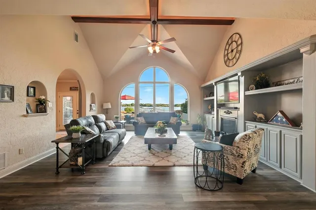 a living room with furniture a chandelier and wooden floor