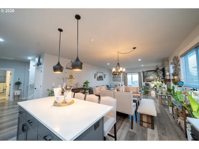 a view of a dining room and livingroom with furniture wooden floor a chandelier