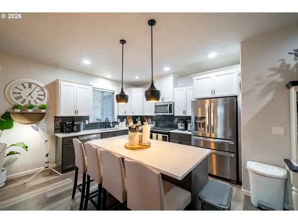 a kitchen with refrigerator and chairs