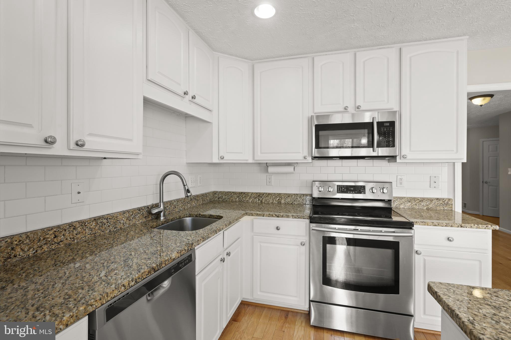 1983 Cullen Way Forest Hill, MD 21050 - Photo 12 of 50 a kitchen with granite countertop a sink stove and microwave