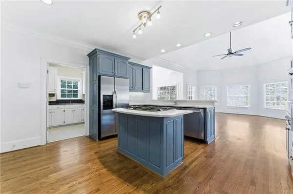 a kitchen with granite countertop cabinets stainless steel appliances and wooden floor