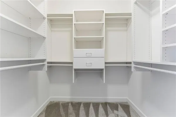 a view of walk in closet with empty racks