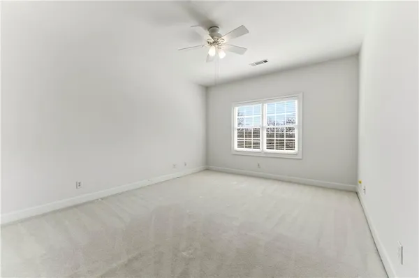 a view of an empty room with a fireplace and a window