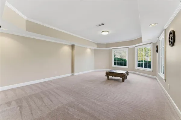a view of an empty room with cabinet and a window