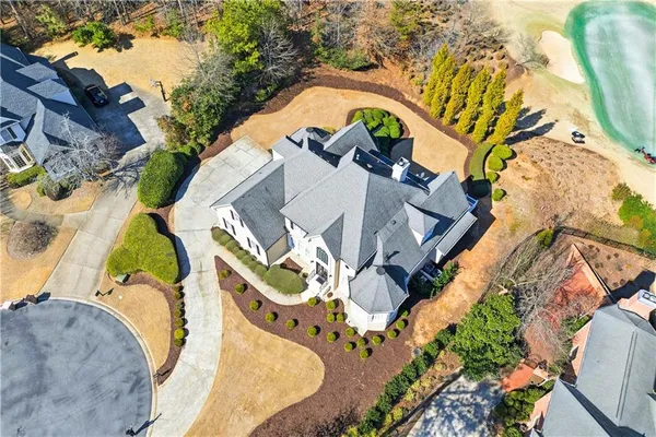 an aerial view of a house with a swimming pool and outdoor seating