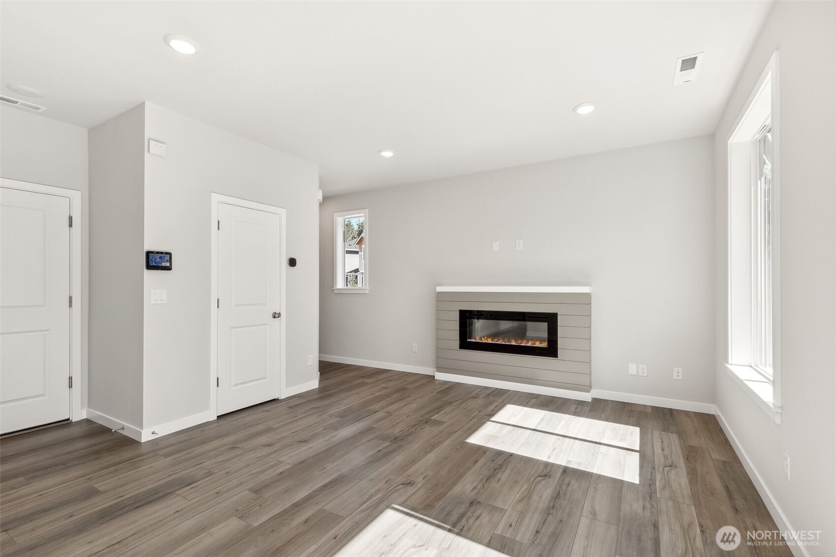 32321 134th Street Southeast Sultan, WA 98294 - Photo 11 of 27 an empty room with wooden floor fireplace and windows