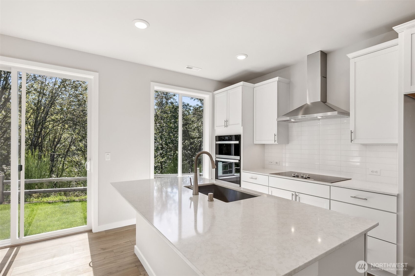 32321 134th Street Southeast Sultan, WA 98294 - Photo 6 of 27 a kitchen with stainless steel appliances granite countertop a stove a refrigerator a sink and white cabinets with wooden floor