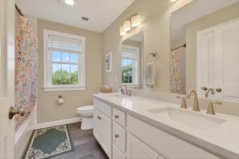 a bathroom with a granite countertop sink mirror and a bathtub