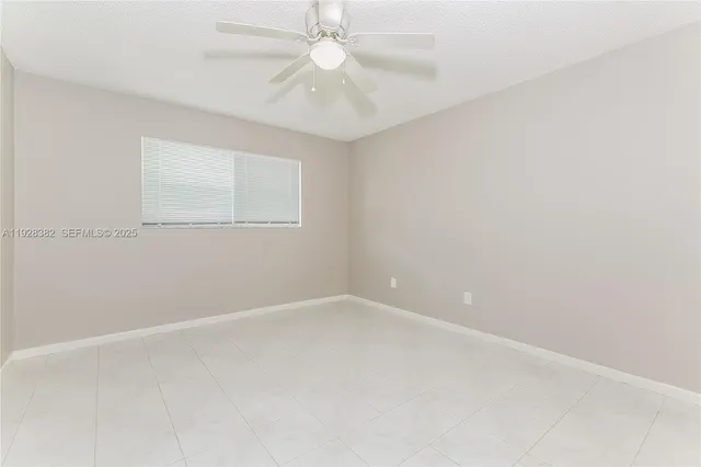 an empty room with a window and a fan