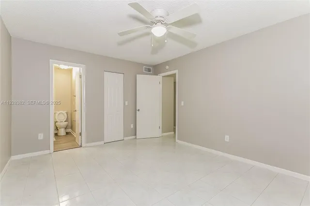 an empty room with a ceiling fan and a window