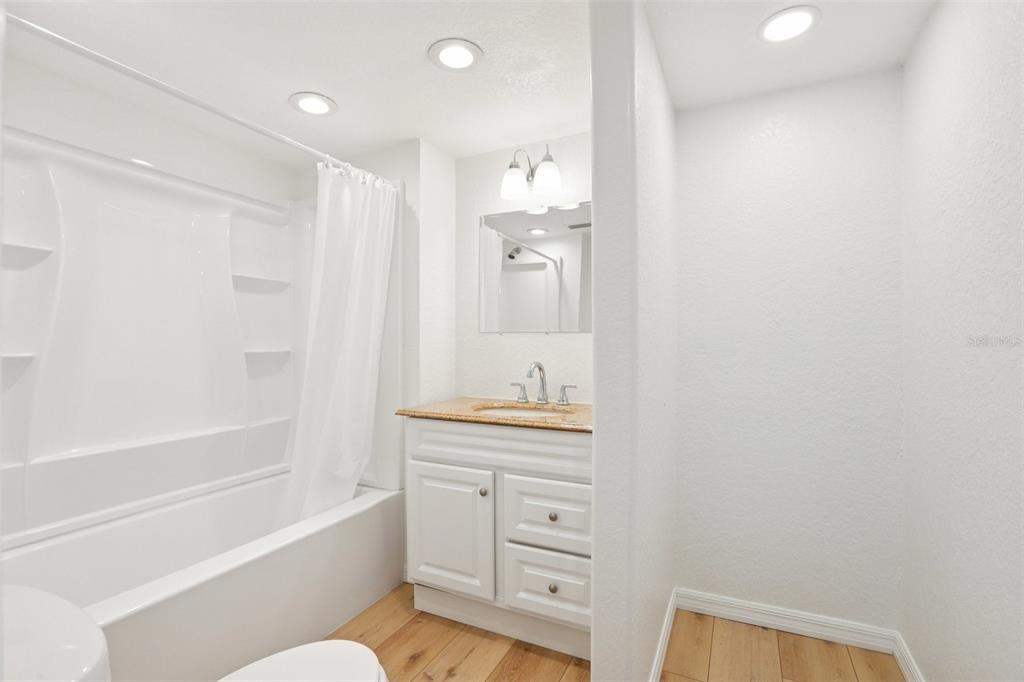 13135 4th Street East Madeira Beach, FL 33708 - Photo 16 of 24 a bathroom with a granite countertop sink a toilet and shower