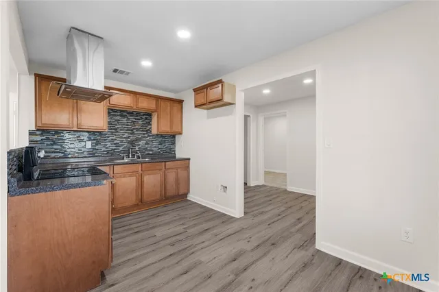 a kitchen with stainless steel appliances granite countertop a stove a sink and a refrigerator