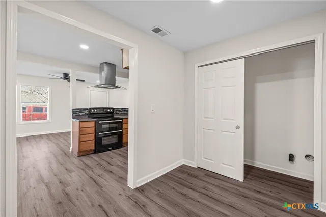 a view of kitchen with wooden floor and electronic appliances