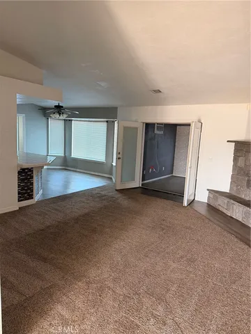 a view of an empty room with a fireplace and a window