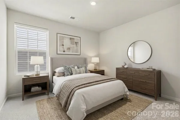 a bedroom with a bed a mirror and a large window