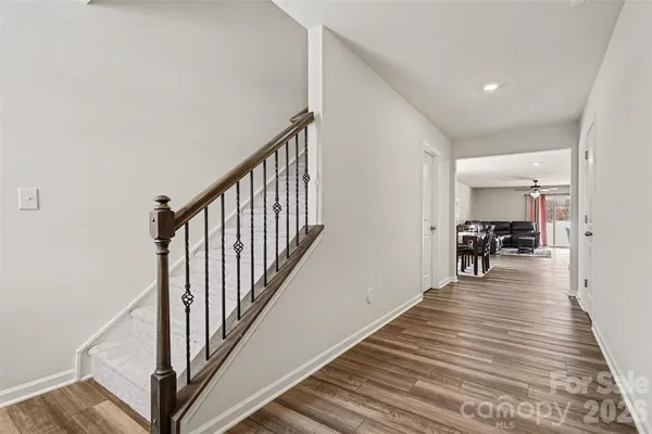 a hallway with wooden floor and dining room