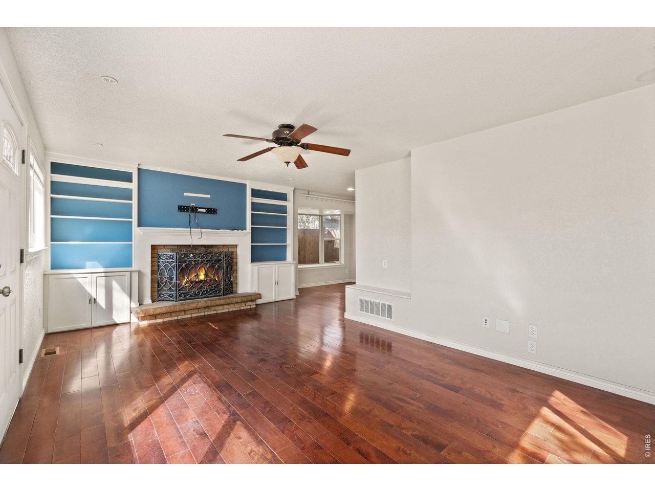 245 6th Street Frederick, CO 80530 - Photo 1 of 17 a view of an empty room with wooden floor fireplace and a window