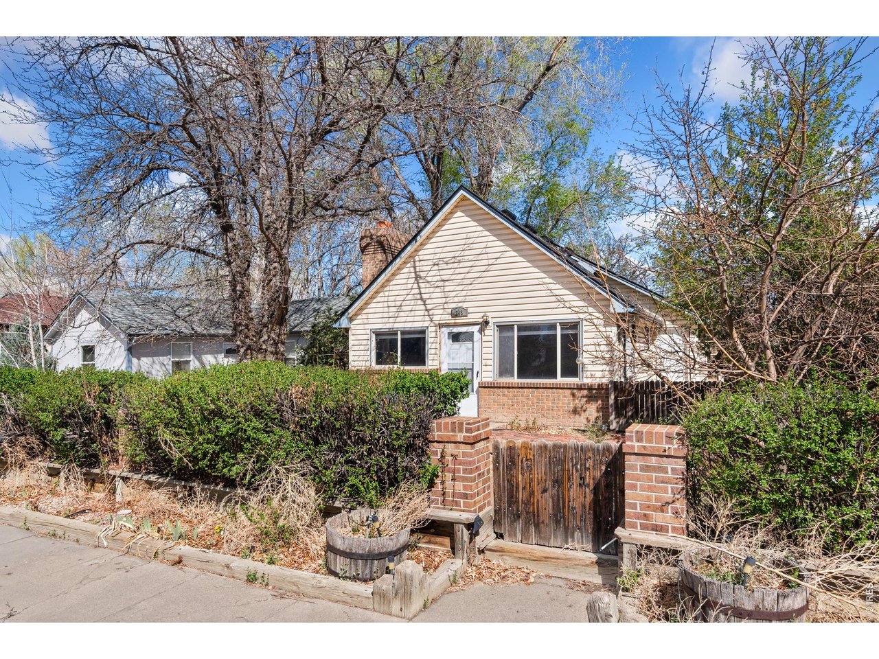 245 6th Street Frederick, CO 80530 - Photo 3 of 17 a view of a white house next to a yard with potted plants