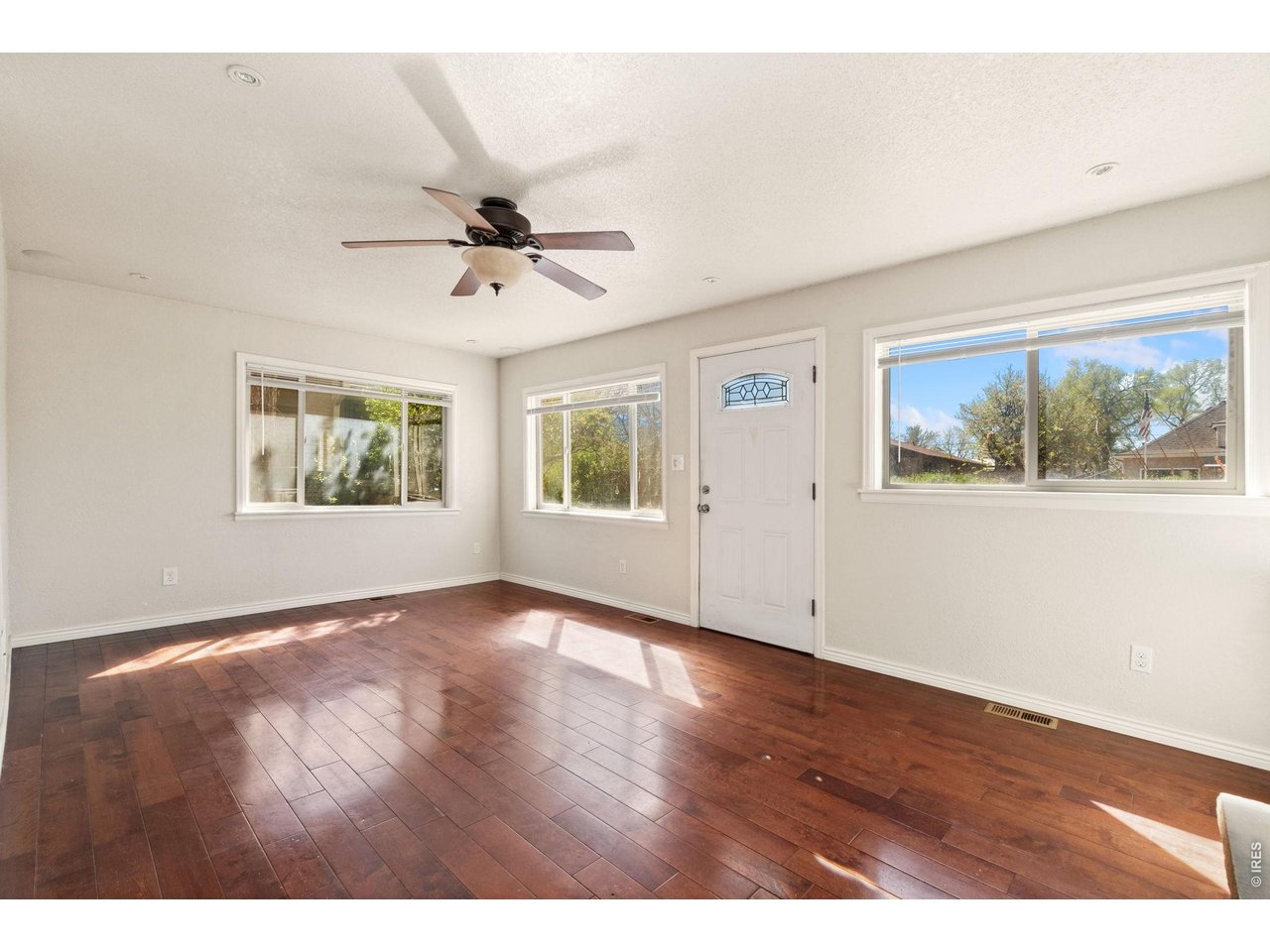 245 6th Street Frederick, CO 80530 - Photo 6 of 17 an empty room with wooden floor ceiling fan and windows