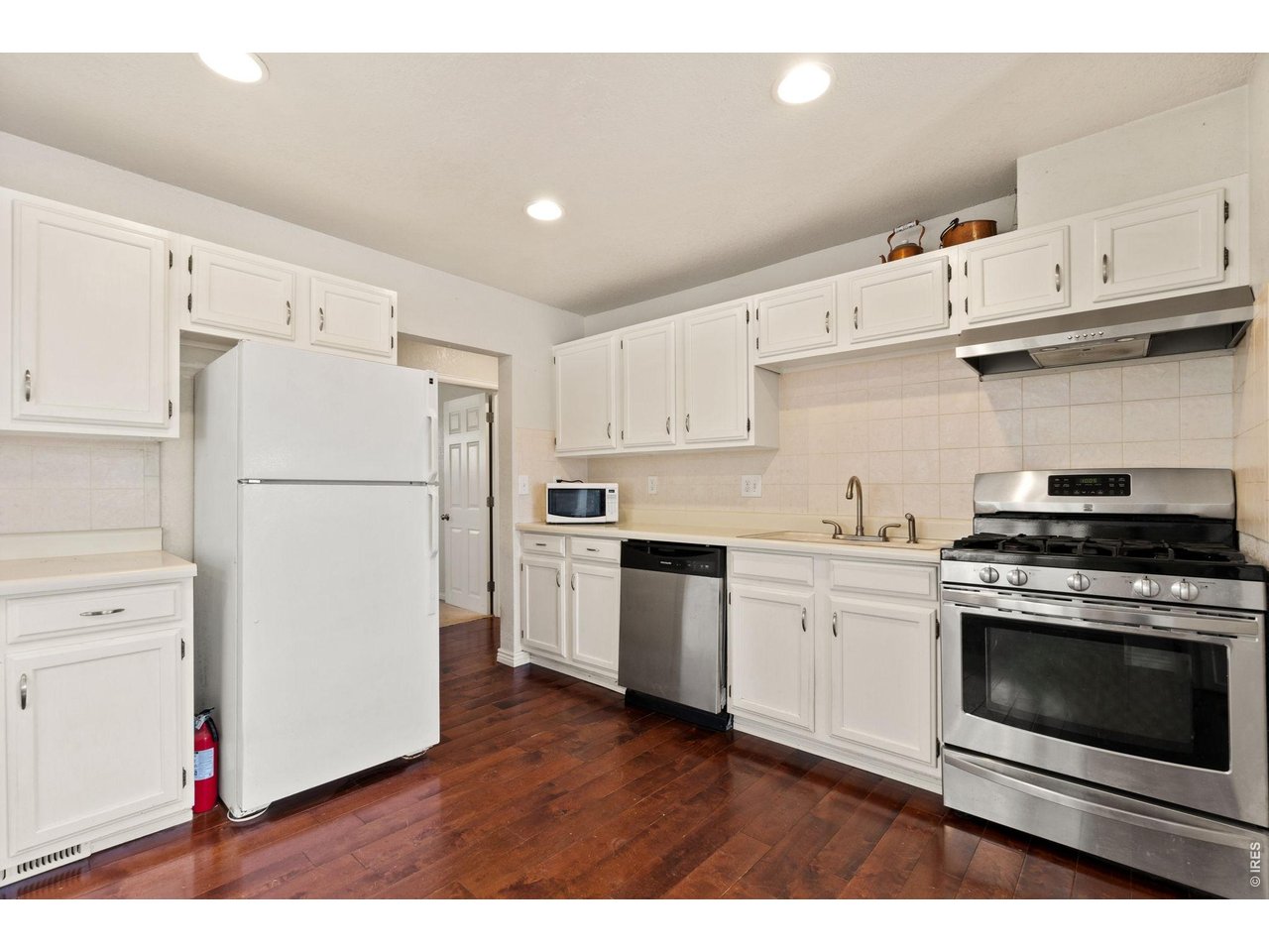 245 6th Street Frederick, CO 80530 - Photo 7 of 17 a kitchen with cabinets stainless steel appliances and wooden floor