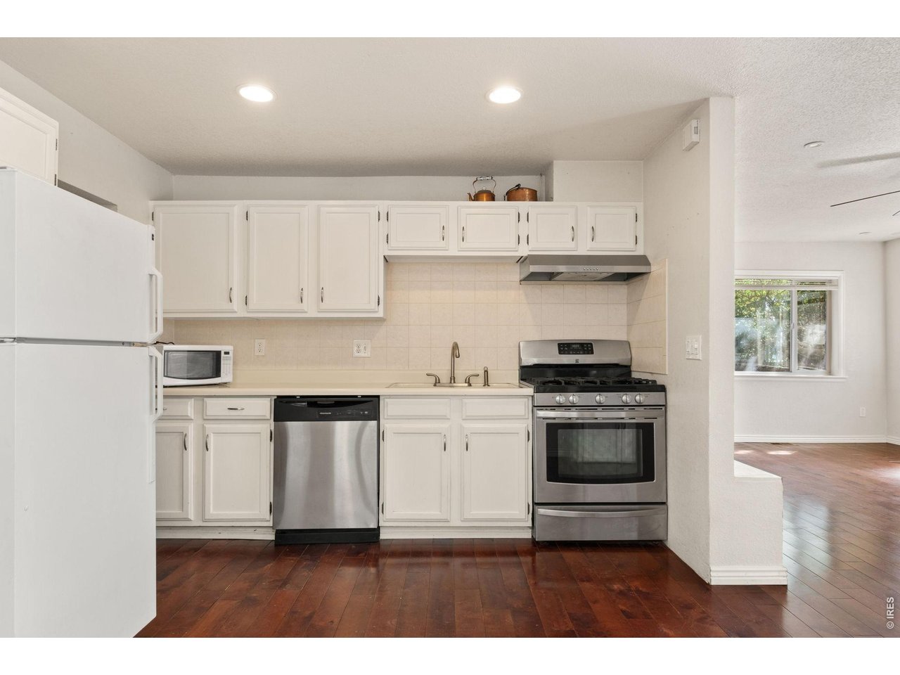 245 6th Street Frederick, CO 80530 - Photo 8 of 17 a kitchen with white cabinets and appliances