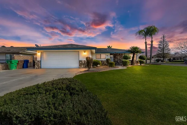 a front view of a house with a yard and trees