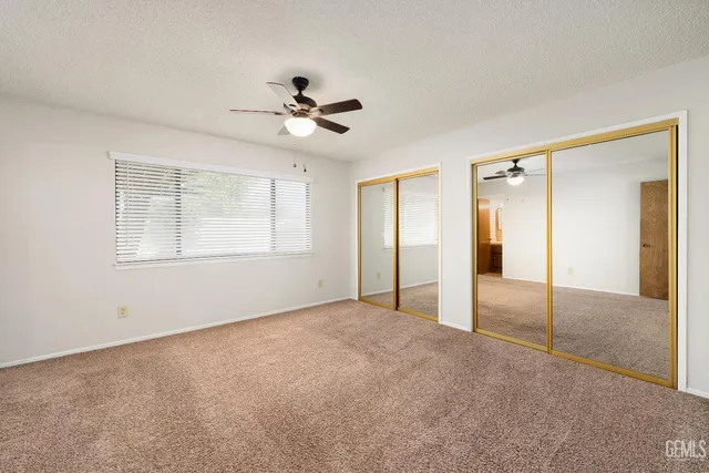 a view of empty room with window and ceiling fan