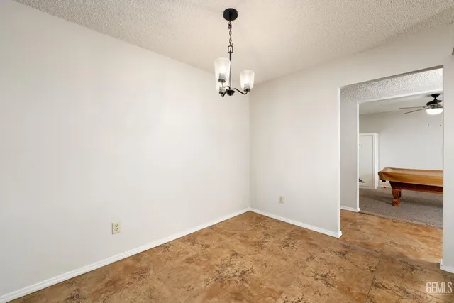 a view of a room with a hanging light and kitchen