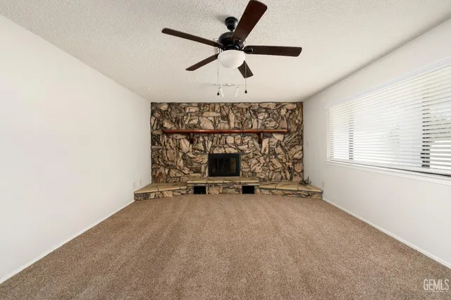 an empty room with a ceiling fan and window