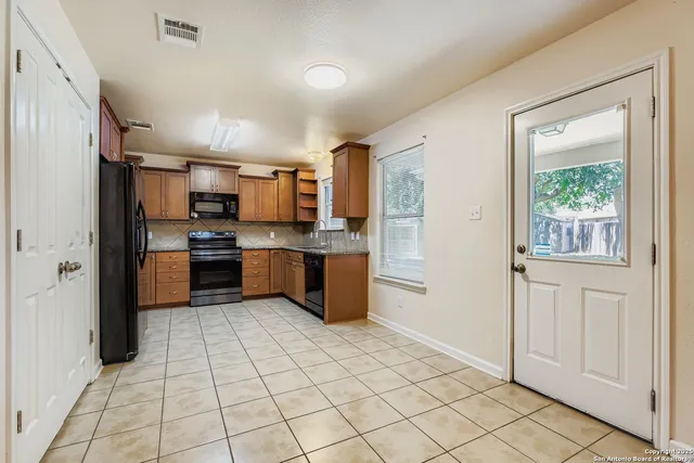 a kitchen with stainless steel appliances granite countertop a refrigerator and a sink