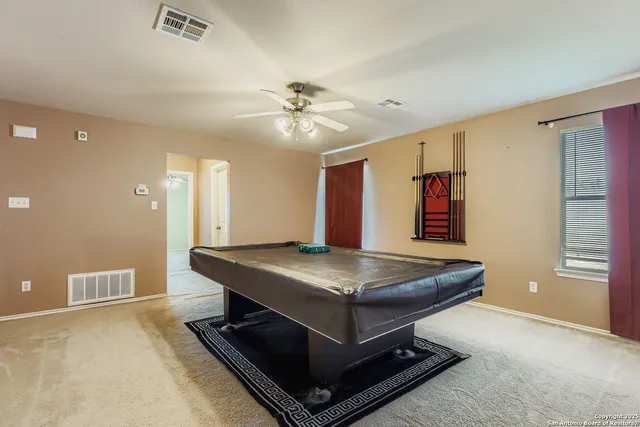 a room with pool table and windows