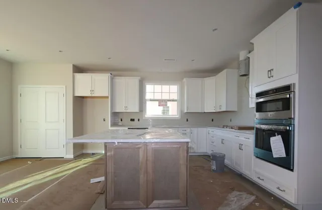 a kitchen with stainless steel appliances granite countertop a sink a stove a refrigerator and cabinets