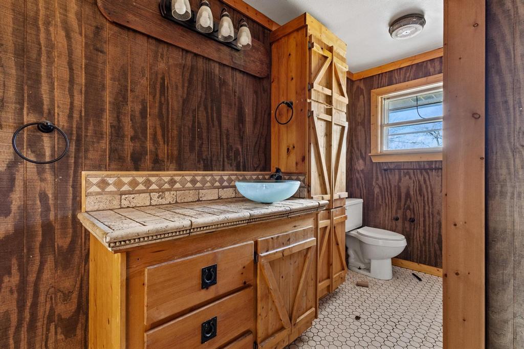 3467 East Fm 120 Denison, TX 75021 - Photo 16 of 38 a bathroom with a granite countertop sink a toilet and a shower curtain