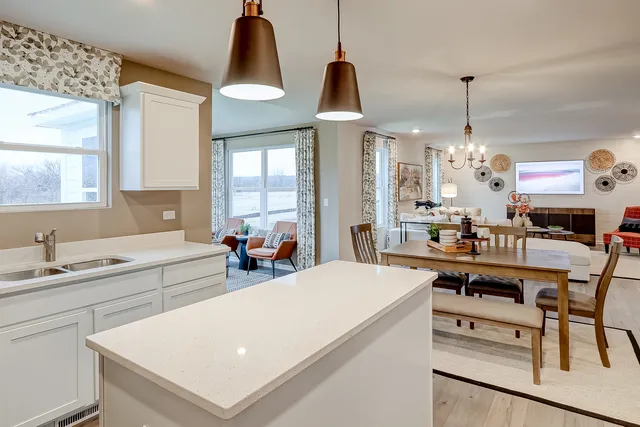 a kitchen with stainless steel appliances a stove a sink dishwasher and white cabinets with wooden floor