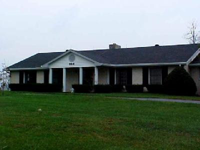 White brick ranch, with black shutters.
