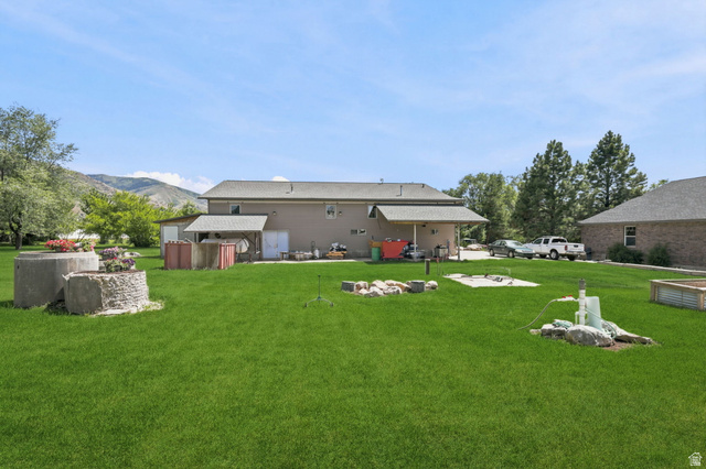 580 North 300 East Logan, UT 84321 - Photo 74 of 74 Expansive lawn area featuring a multi-level concrete planter, a covered patio structure, and a raised garden bed