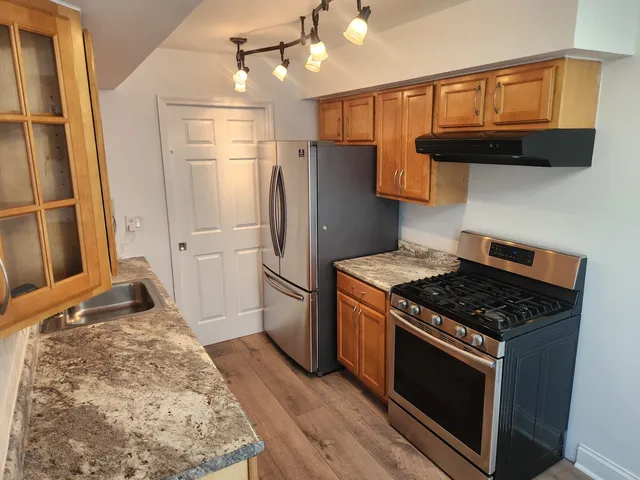 a kitchen with granite countertop a stove and a refrigerator